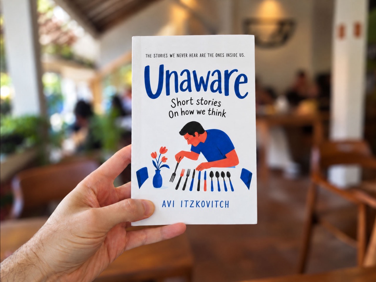 Avi Itzkovitch holding a copy of Unaware